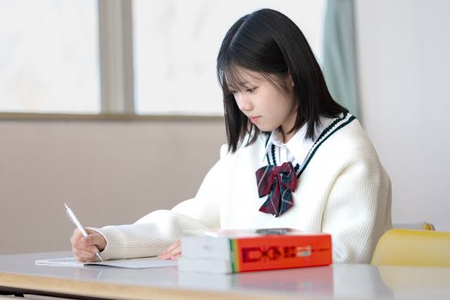 机に向かって勉強をする女子生徒