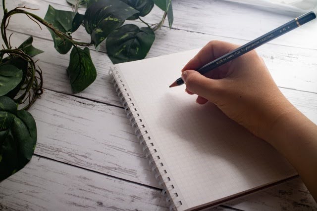 ノートに鉛筆で書き込む様子